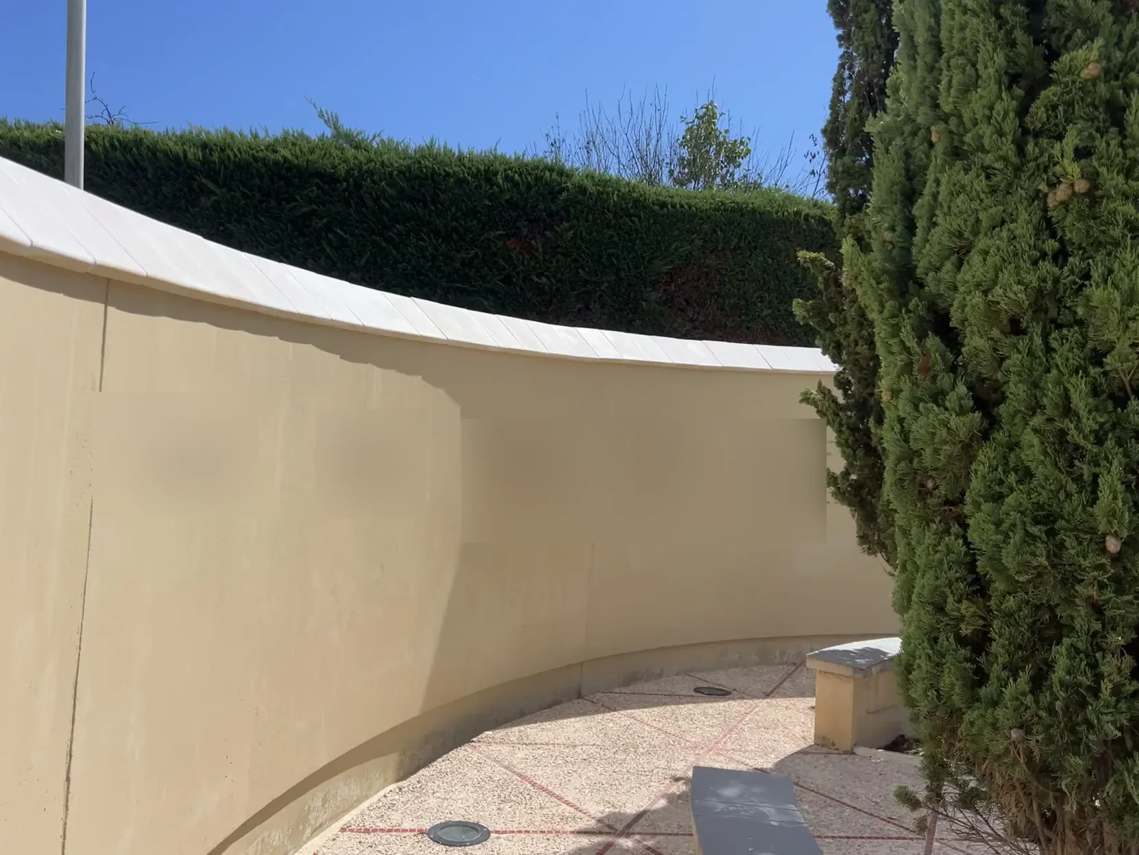 Jardin paisible avec banc en pierre et cyprès chez marbrerie-pompes-funebres-mauvezin à Mauvezin