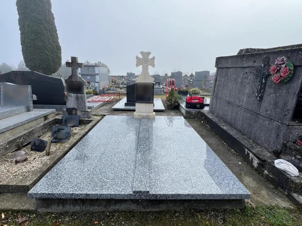 Tombe en granit avec grande croix blanche au cimetière, marbrerie-pompes-funebres-mauvezin à Mauvezin