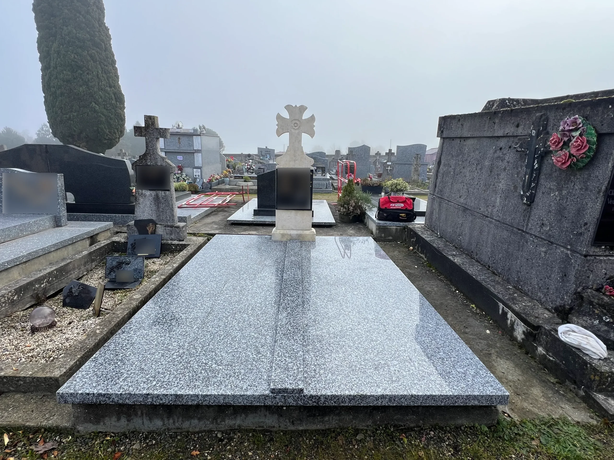 Tombe en granit avec grande croix blanche au cimetière, marbrerie-pompes-funebres-mauvezin à Mauvezin