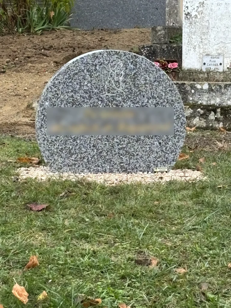 Pierre tombale ronde avec ange gravé sur gravier au cimetière, marbrerie-pompes-funebres-mauvezin à Mauvezin