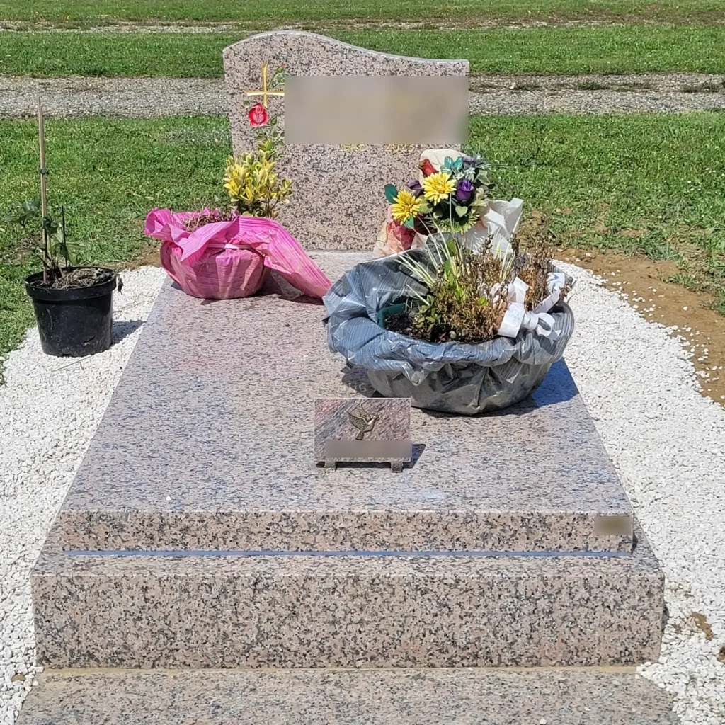 Tombe en granit fleuri entretenue par marbrerie-pompes-funebres-mauvezin dans un cimetière paisible à mauvezin