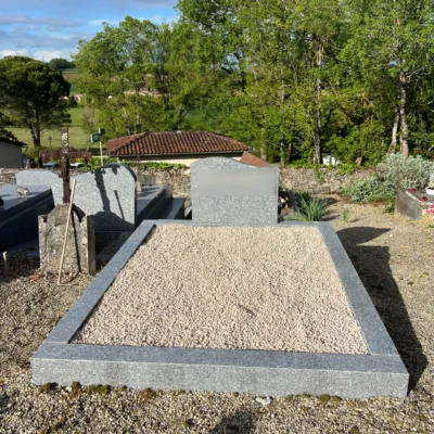Tombe en granit gris avec stèle sobre dans un cimetière paisible, marbrerie-pompes-funebres-mauvezin à Mauvezin