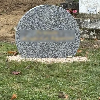 Pierre tombale ronde avec ange gravé sur gravier au cimetière, marbrerie-pompes-funebres-mauvezin à Mauvezin