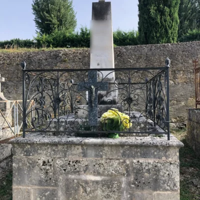 Tombe ancienne avec crucifix et fleurs artificielles au cimetière rural de mauvezin, marbrerie-pompes-funebres-mauvezin